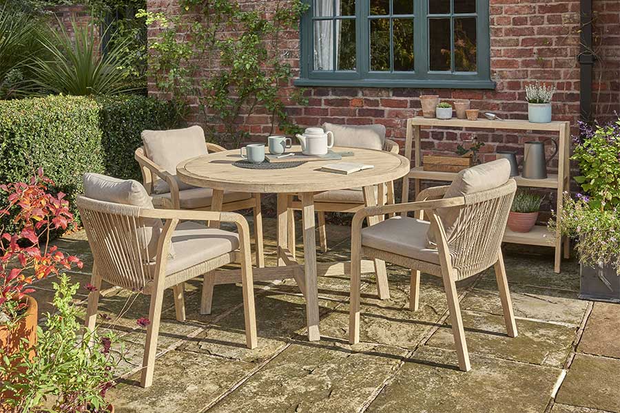 Cottage patio with Kettler Cora hardwood round garden table and luxury chairs