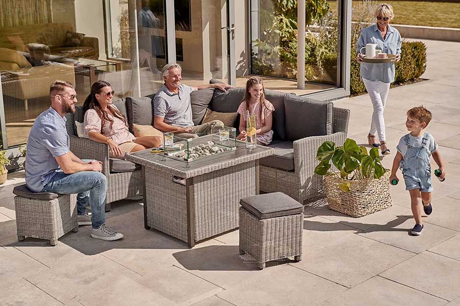 Family enjoying the garden sitting around a Kettler Palma corner lounge set